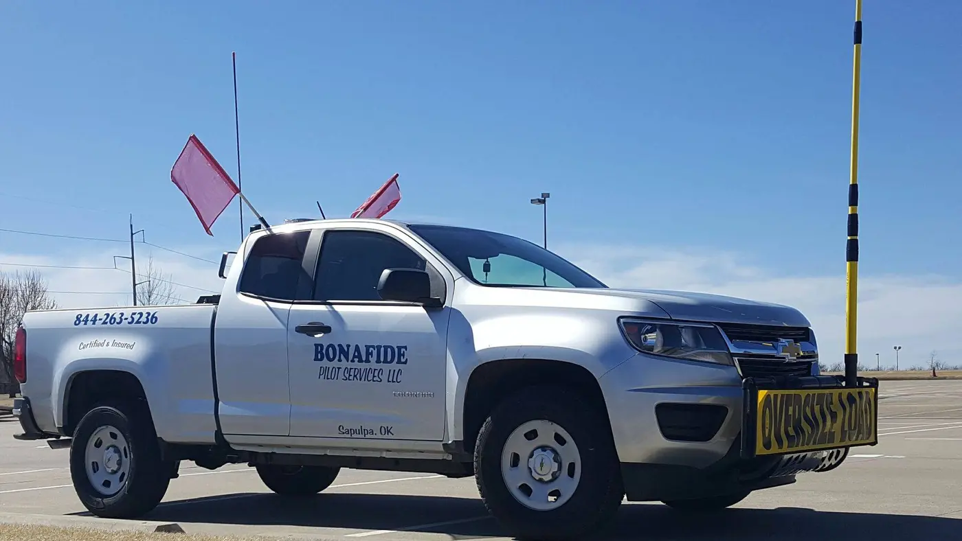 Bonafide pilot truck with a height pole, flags and an oversize load sign